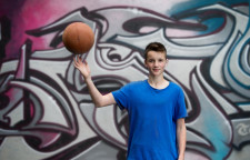 Un enfant tient un ballon de basket en équilibre sur un doigt.