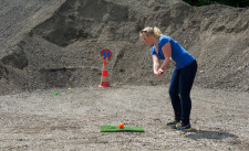 Una giocatrice cerca di colpire un pannello segnaletico collocato sopra un cono.