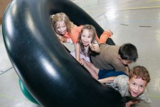 Dei bambini rotolano gioiosi all'interno di una camera d'aria di grandi dimensioni