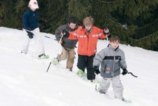 Eine Gruppe von Kindern beim Schneeschuhlaufen in verschneiter Landschaft.