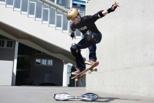 Un giovane esegue un salto con lo skateboard su un piazzale
