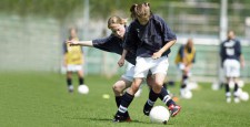 Deux filles élèves jouent au football.