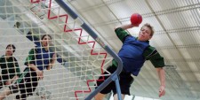 Un garçon lance une balle contre le cadre de tchoukball.