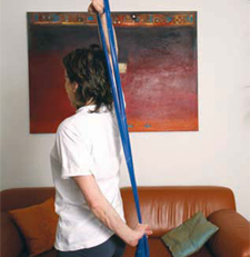 Una donna esegue degli esercizi dietro la schiena con un elastico thera-band