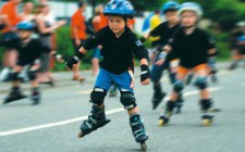 Kleine Kinder mit Helm beim Inline-Skaten.