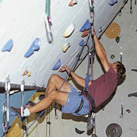 Un giovane si arrampica su una parete indoor
