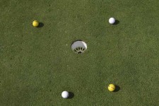 Des balles de golf proches d'un trou.