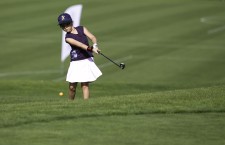 Mädchen beim Abschlag auf freier Golfbahn
