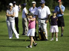 Une jeune fille frappe une balle de golf.