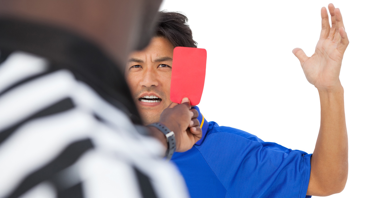 Foto: un arbitro mostra il cartellino rosso a un giocatore che si arrabbia moltissimo