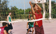 Ein Madball-Spieler fängt einen Ball vor dem Volleyball-Netz auf. 