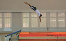 Un athlète effectue un saut roulé.
