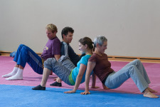 Quatre enseignants effectuent un exercice à deux dans une salle de sport.