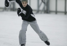Un jeune garçon patine sur une patinoirre.