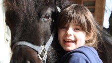 Foto: una bambina abbracciata a un pony