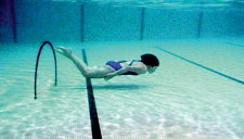 Mädchen taucht Unterwasser durch einen Ring