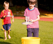 Deux enfants transportent un verre d'eau sur une raquette.
