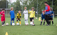 Foto: Fussballtrainer gibt Kinder Anweisungen.