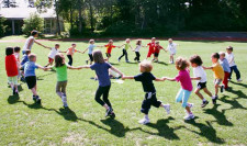 Foto: Kinder rennen im Kreis während sie sich an den Händen halten.