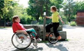 Ein Kind im Rollstuhl und eines auf dem Einrad üben gemeinsam.
