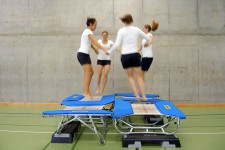 Quatre jeunes femmes sautent sur quatre mini-trampoline.