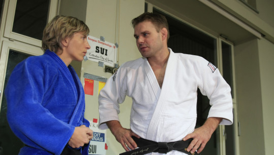 Un allenatore di judo ascolta un'atleta che gli parla