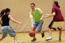 Tre giovani ragazze mentre giocano a pallacanestro
