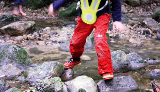 Un enfant traverse un ruisseau.