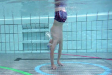 Un bambino in appoggio rovesciato sott'acqua