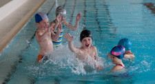 Foto: alcuni bambini giocano in acqua spruzzandosi a vicenda.
