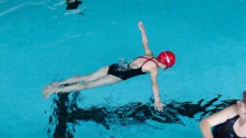Foto: Ein Mädchen schwebt bäuchlings auf dem Wasser.