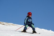 Un bambino di tre anni scia su un dolce pendio innevato