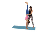 Foto: Yogalehrerin hilft Schülerin bei der Ausführung einer Übung.