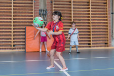 Mädchen fasst den Ball mit der Hand an.