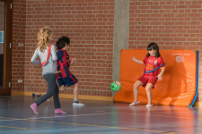 Drei Kinder beim Fussballspiel auf eine Matte.