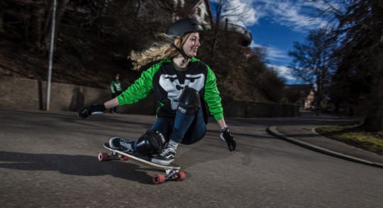 Foto: una ragazza esegue una curva su un longboard skate