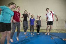 Des jeunes sautent sur des tapis de gymnastique.