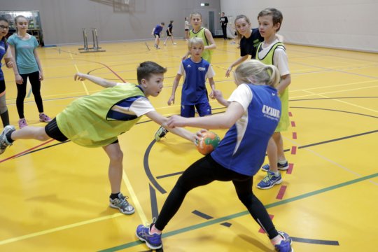 Bild: Ein Schüler tupft eine Kameradin mit dem Ball ab.