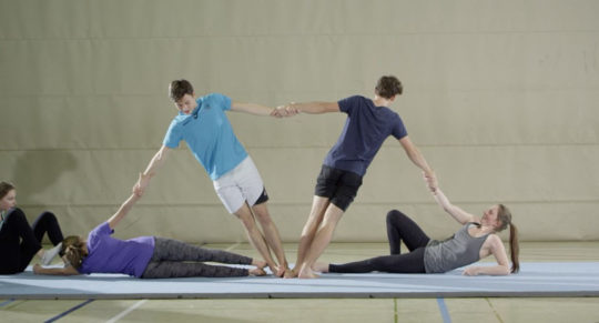 Des élèves forment une figure acrobatique.