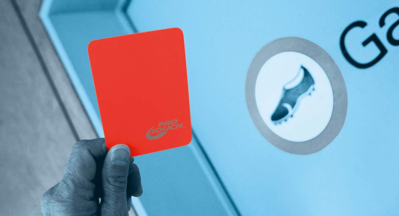 Hand zeigt rote Karte, im Hintergrund eine Garderobentüre.