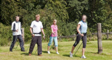 Un groupe de quatre personnes fait du nordic walking.
