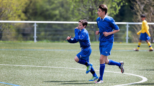 Deux jeunes de taille différentes jouent dans la même équipe.