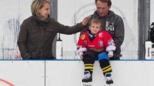 Foto: due genitori di un piccolo giocatore di hockey si occupano amorevolmente del figlio