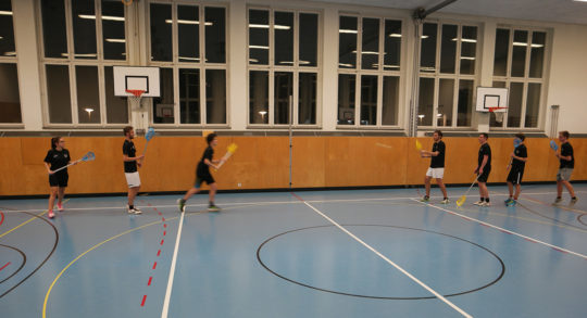 Foto: due squadre impegnate a giocare a intercrosse in una palestra